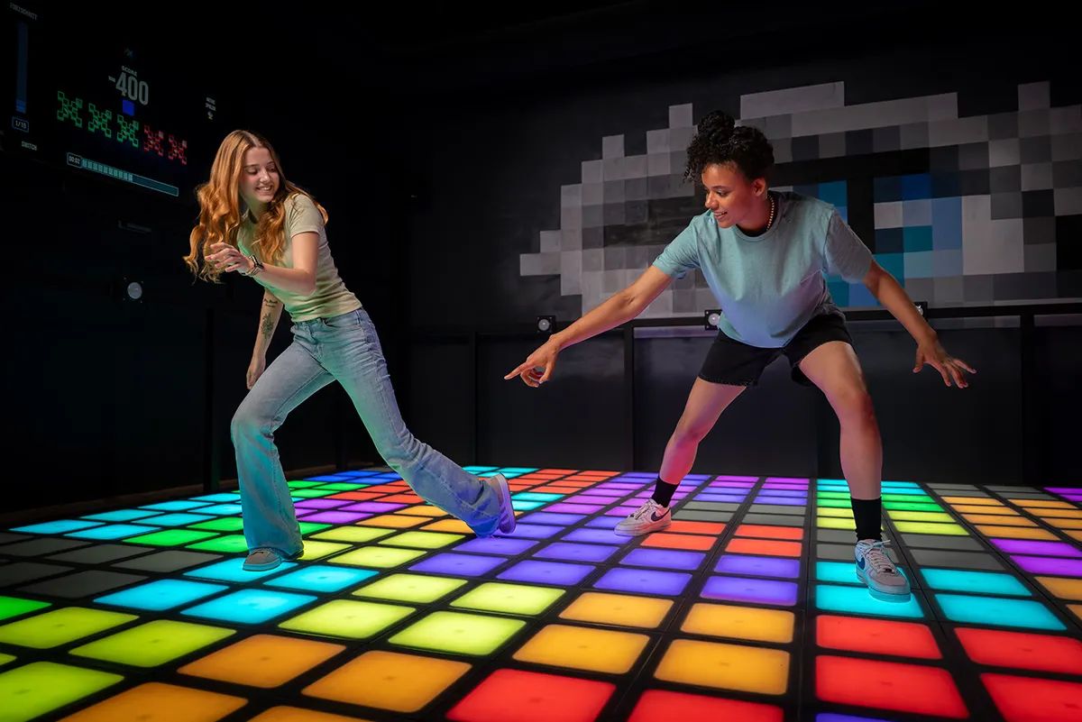 Players using a colorful interactive LED floor in an entertainment venue